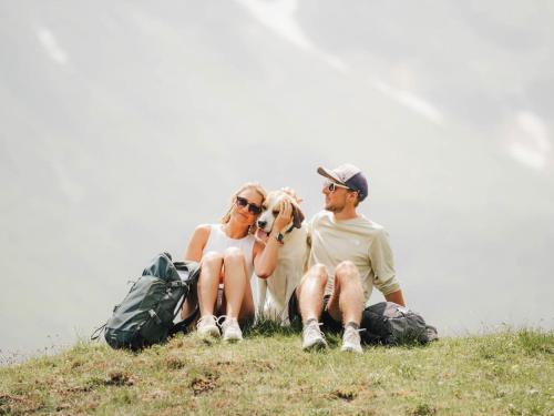 a group of people sitting on a hill with their backpacks at Hotel Zum Stern - Bergbahnen inklusive im Sommer 2025 in Bad Hofgastein