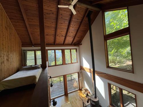 a bedroom in a house with windows and a bed at Cabin A MtFuji view, BBQ, lake Saiko 3mins, hammock, wood deck in Narusawa