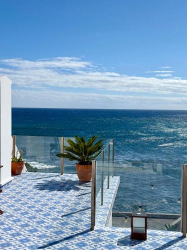a walkway leading to the ocean with a potted plant at Esplanada do Ilhéu in Vila Franca do Campo