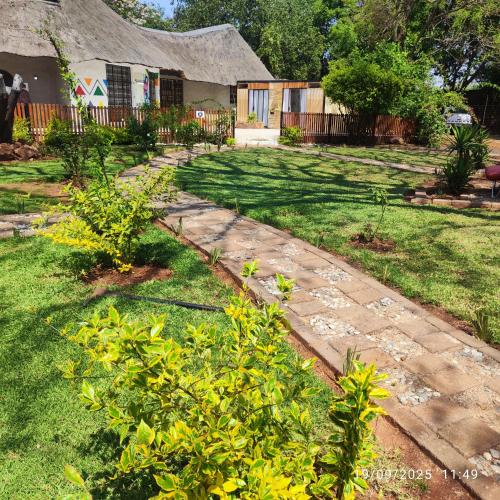 a garden with a stone walkway in front of a house at Pamensky Bush Lodge and Spa in Hartbeespoort