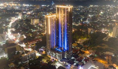a tall building with blue lights in a city at night at NEW and COZY! Good for 1-5 Guests, 1BR, free Pool & Gym, Kids Place and Billard in Horizon 101 in Cebu City