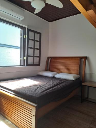 ein Schlafzimmer mit einem großen Bett mit Fenster in der Unterkunft Casa praia fortaleza pé na areia in Ubatuba
