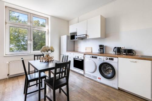 a kitchen with a table and a washing machine at Key2Komfort in Duisburg