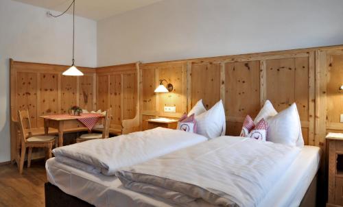 a bedroom with a large bed and a table at Hotel - Gasthof Märzenklamm in Stumm