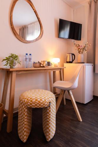 a room with a table and a chair and a mirror at BadHotel Noordwijk in Noordwijk