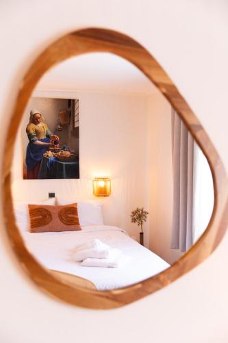 a bedroom with a bed and a mirror at BadHotel Noordwijk in Noordwijk