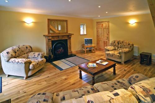 a living room with two couches and a fireplace at 2 Bed in Maam oc-i252 in Claggan