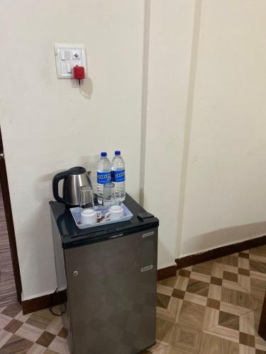 a small refrigerator with water bottles on top of it at Hotel The Baga Prime in Baga