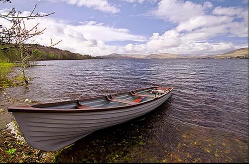 a boat sitting on the shore of a lake at 2 Bed in Oughterard oc-i492 in Porridgetown