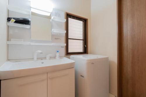 Un baño con lavabo y lavadora. en kinyo inn 2 101, en Osaka