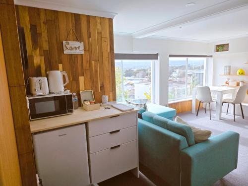 a kitchen with a couch and a microwave and a table at Ers's on Tamar in Riverside