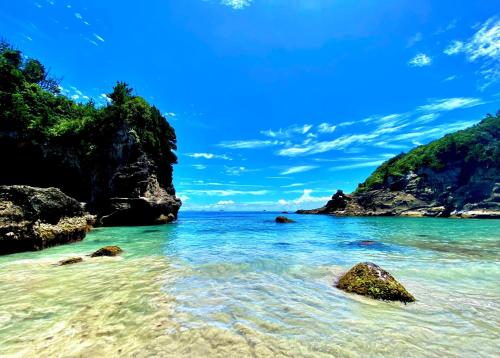 a beach with rocks in the water on a sunny day at プライベート天然温泉 - 広々清潔 - 素敵な非日常! Private Hot Spring - Spotless Modern Japanese in Ito