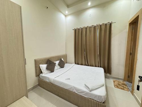 een slaapkamer met een bed met witte lakens en kussens bij Era Hotel and Reosrt in Kota