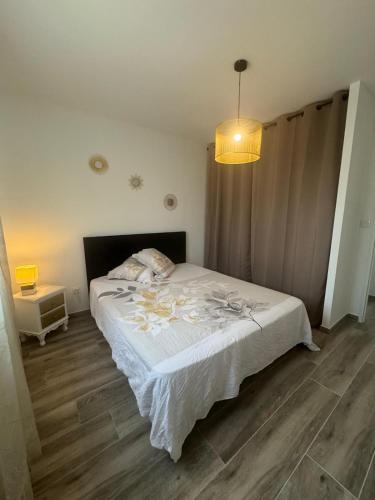 a bedroom with a white bed and a lamp at Villa Maeva Florensac in Florensac