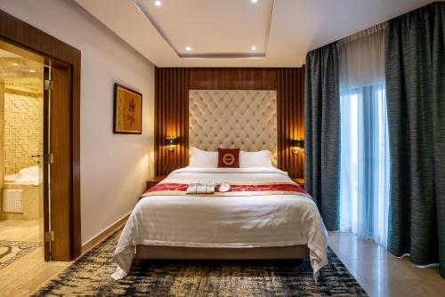 a bedroom with a large bed and a large window at The Lilygate Lagos in Lagos