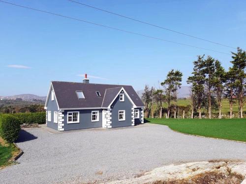 Una casa azul y blanca en un camino de grava en 3 Bed in Castletownbere oc-i487, en Castletownbere