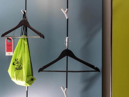 a pair of hangers with a green bag at ibis Styles Stuttgart Vaihingen in Stuttgart