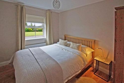 a bedroom with a white bed and a window at 4 Bed in Beara oc-i437 in Adrigole