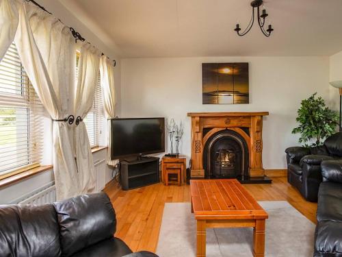 a living room with a couch and a fireplace at 4 Bed in Ballydavid oc-ii16672 in Murreagh