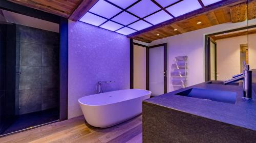 ein Badezimmer mit großer Badewanne und Waschbecken in der Unterkunft MGM Hôtels & Résidences - Le Chalet Apsara in Méribel