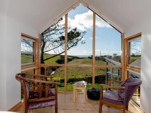 Westtownにある3 Bed in Tramore oc-ii11304の大きな窓と椅子2脚が備わる客室です。