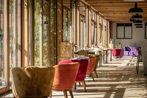 a row of tables and chairs in a room with windows at Tannerhof - Mein Versteck in den Bergen in Bayrischzell