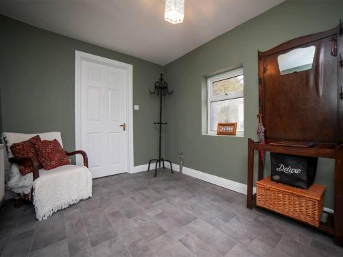 a living room with a chair and a white door at 3 Bed in Gweesalia oc-ii16998 in Tullaghanbaun