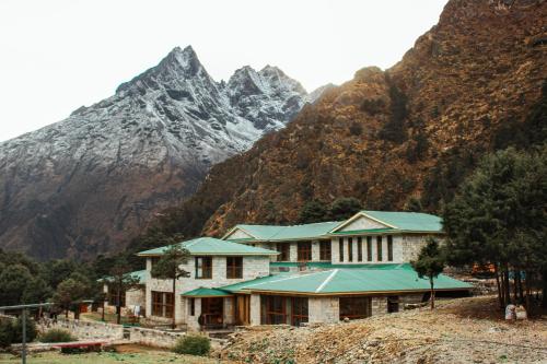 a house with a mountain in the background at Mountain Lodges of Nepal Deboche in Thyāngboche