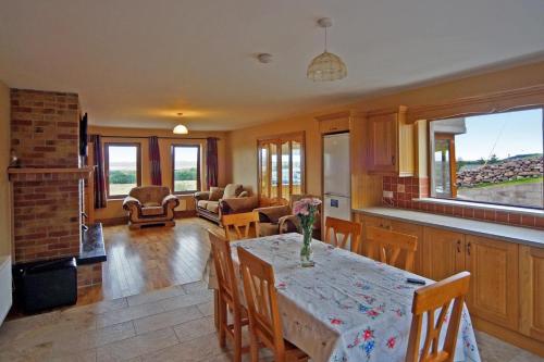 a kitchen and living room with a table and chairs at 4 Bed in Inch oc-i190 in Inch