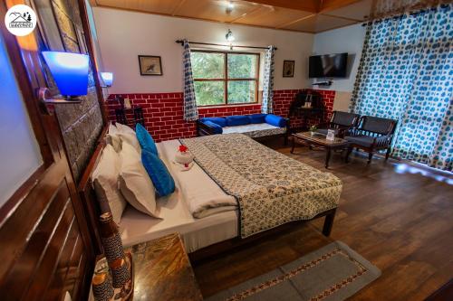 a bedroom with a bed and a living room at Hotel Udechee Huts, McLeod Ganj in McLeod Ganj