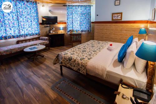 a hotel room with a bed and a couch at Hotel Udechee Huts, McLeod Ganj in McLeod Ganj