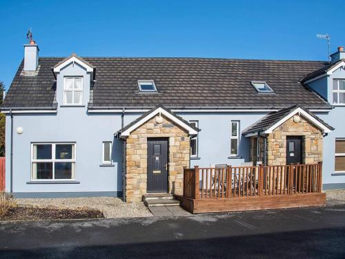 a white house with a wooden fence in front of it at 4 Bed in Portnoo oc-ii16953 in Clogher