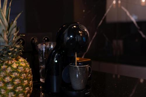 a bottle of wine in a cup next to a pineapple at Apartamenty Dąbrówka Beauty - w parku leśnym , sauna in Jelenia Góra