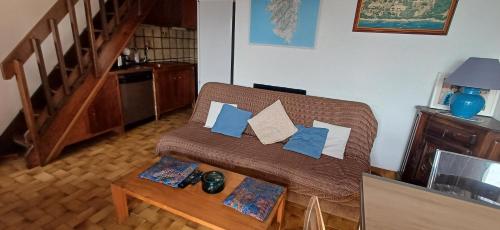a living room with a couch with pillows and a table at Bord de mer in Serra-di-Ferro