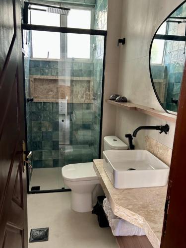 a bathroom with a toilet and a sink and a shower at Iara & Muira Apartments in Belém