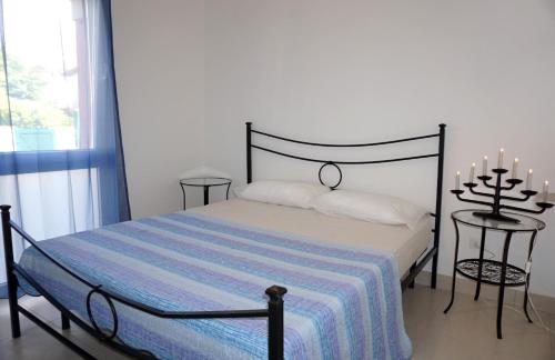 圣玛格丽塔波尔勒港Apartment with private garden的一间卧室配有一张床和两张带蜡烛的桌子。