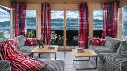 een woonkamer met banken, tafels en ramen bij Wygodno in Szlembark