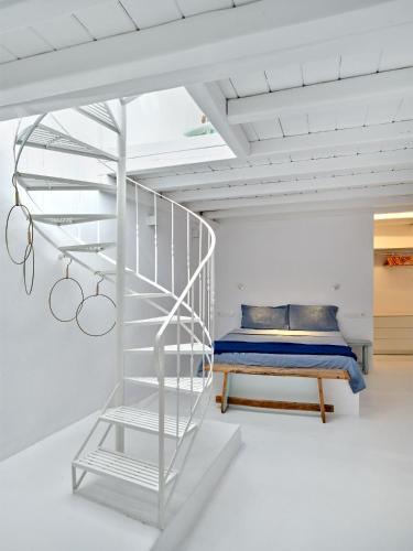 a bedroom with a bunk bed and a spiral staircase at Brunella Paros in Naousa