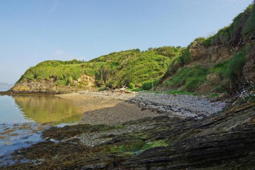 a beach with rocks and grass on a hill at 3 Bed in Duncannon oc-i041 in Duncannon