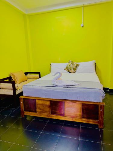 a bed in a room with a green wall at Diamond Pool House in Panadura
