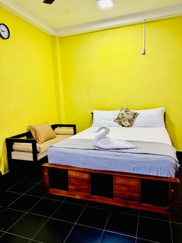 a bed in a room with a yellow wall at Diamond Pool House in Panadura