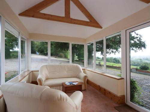 a living room with two chairs and a table and windows at 2 Bed in Lismore oc-ii06400 in Tallowbridge