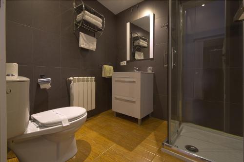 ein Bad mit einem WC und einer Dusche in der Unterkunft Hostal Misericordia in León