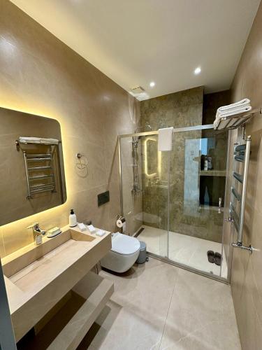 a bathroom with a shower and a toilet and a sink at Sea Breeze Polo Residence in Baku
