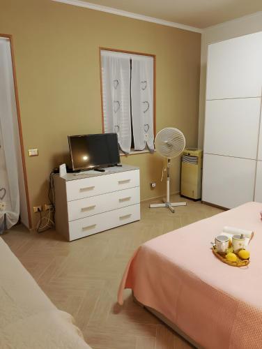 a bedroom with a bed and a dresser with a television at Casa Domenico in Messina