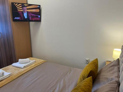 a room with a bed with a tv on the wall at Oaza Apartman stan na dan in Zaječar