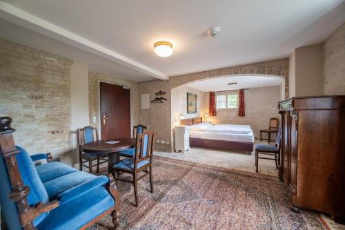 a room with a couch and a bed and a table at Gutshaus Lietzow in Nauen