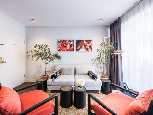 a living room with a couch and some chairs at Mercure Hotel Frankfurt Airport Langen in Langen