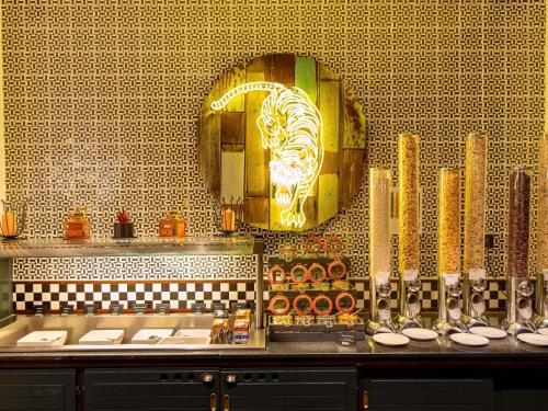 a restaurant with a gold lion head on a wall at Mercure Hotel Frankfurt Airport Langen in Langen