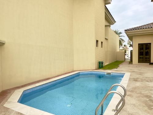 a swimming pool in front of a building at Palm Villa F, Palm Jumeirah - Mint Stay in Dubai